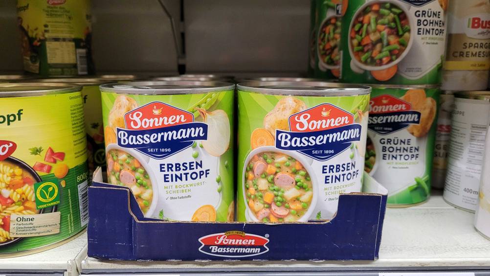 Mehrere Dosen der getesteten Erbsensuppe in einem Karton im Verkaufsregal stehend.