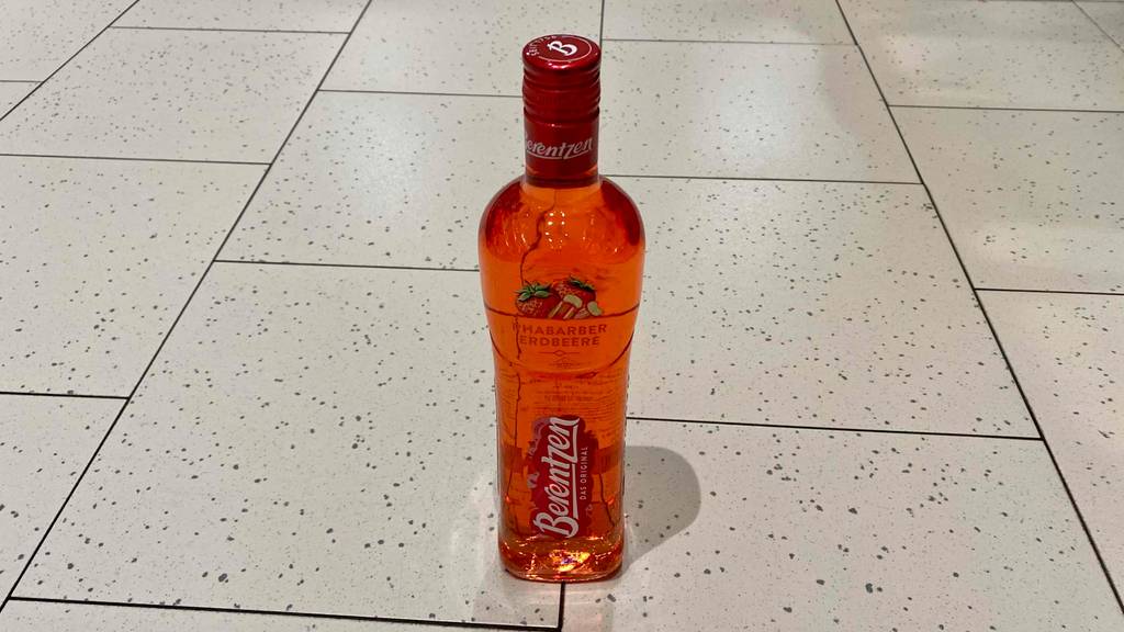 Eine Flasche getestetes Erdbeerlikör steht auf dem Boden. 