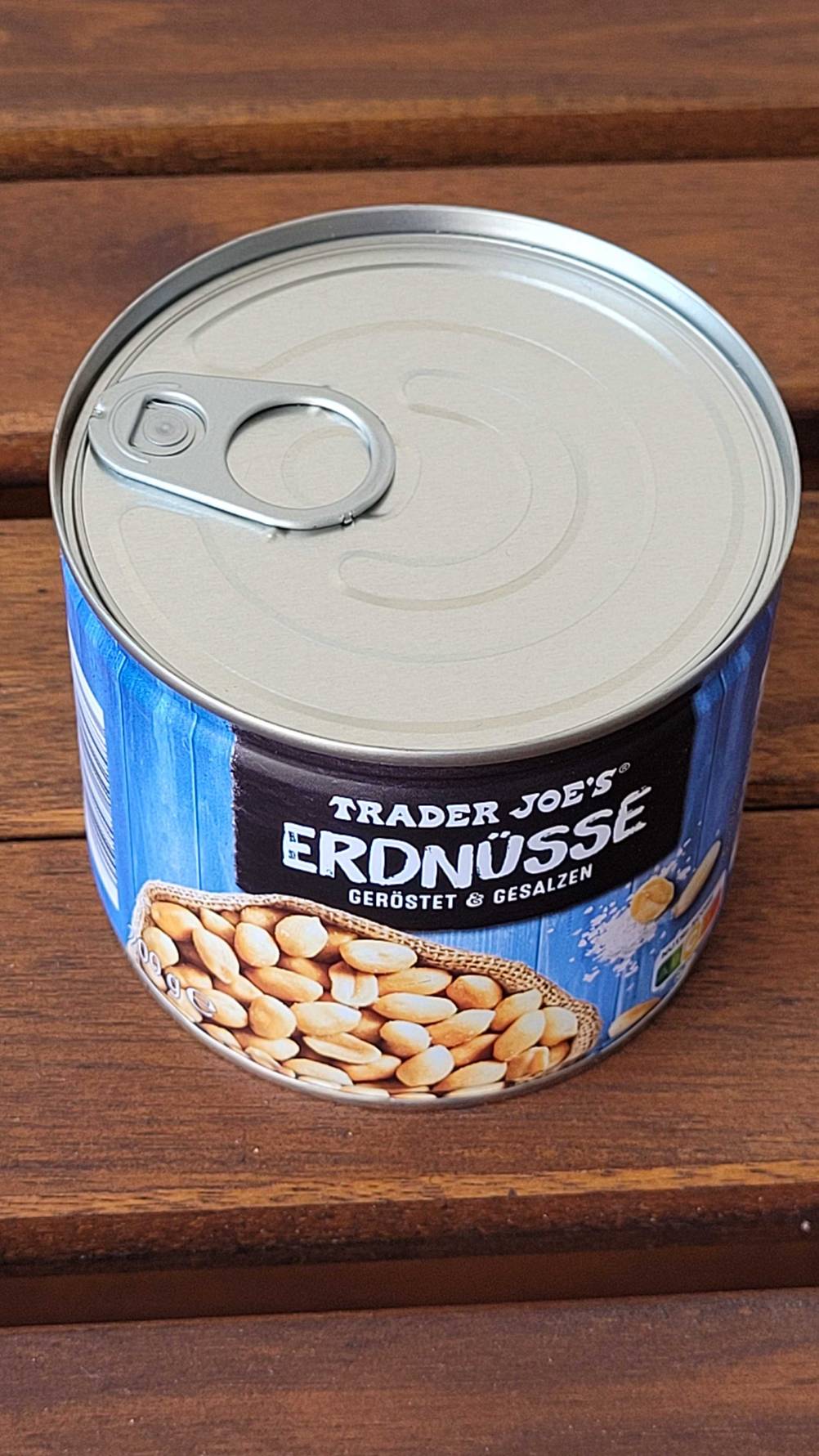 Eine Dose der getesteten Erdnüsse von schräg oben auf einer Holzfläche.