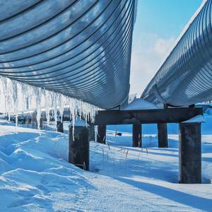 Russische Erdgas-Pipelines aif Stelzen in verschneiter Landschaft
