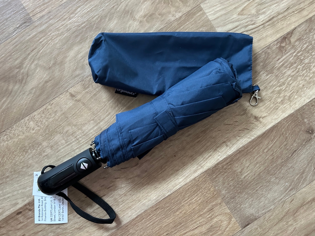 Regenschirm-Test: Blauer Regenschirm liegt auf Boden