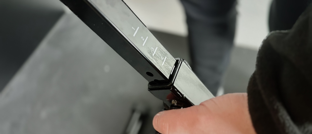 Jemand stellt die Höhe des Ergometers von Tretmann ein.