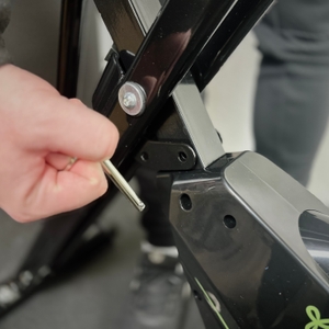 Der Stift wird herausgezogen, um das Ergometer einzuklappen.