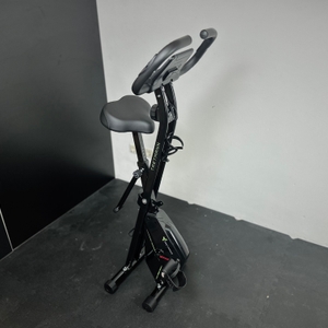 Das Ergometer von Tretmann steht zusammengeklappt in einer Ecke eines Raumes.