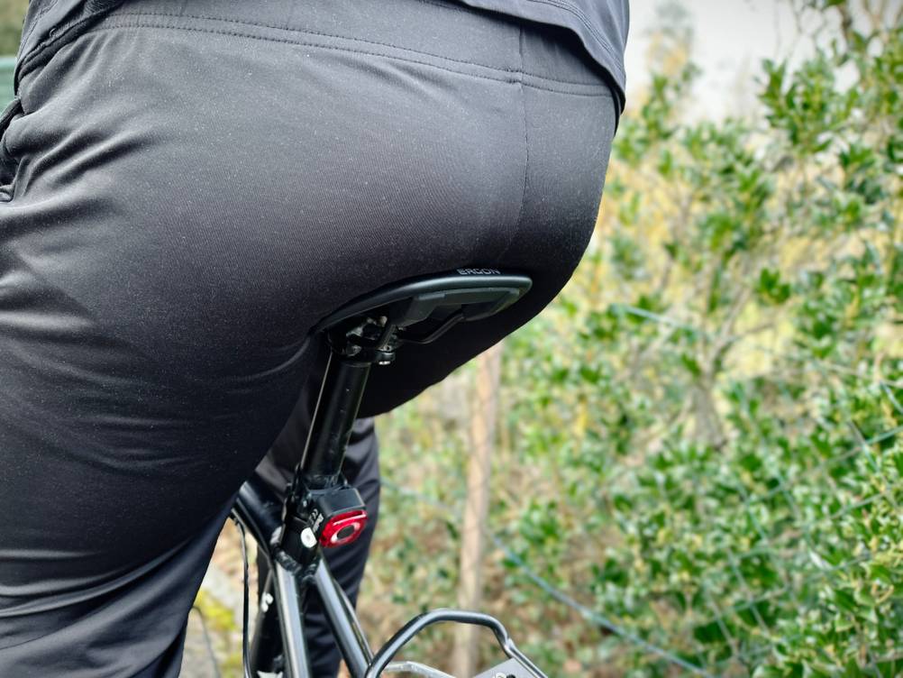 Der Ergon-SMC-Sport-Sattel ist auf einem Fahrrad montiert und wird während der Fahrt genutzt. Der Fahrer sitzt aufrecht, das Foto zeigt den Sattel im Einsatz von hinten.