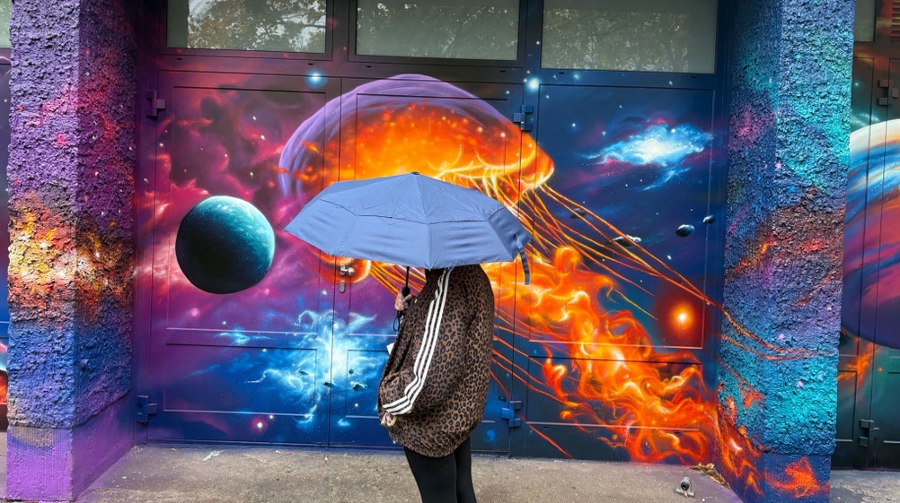 Regenschirm von der Seite vor bemalter Wand