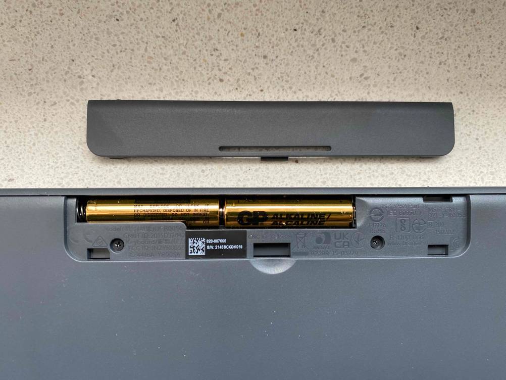 Im Test: Nahaufnahme des geöffneten Batteriefachs einer ergonomischen Tastatur, daneben der Deckel.
