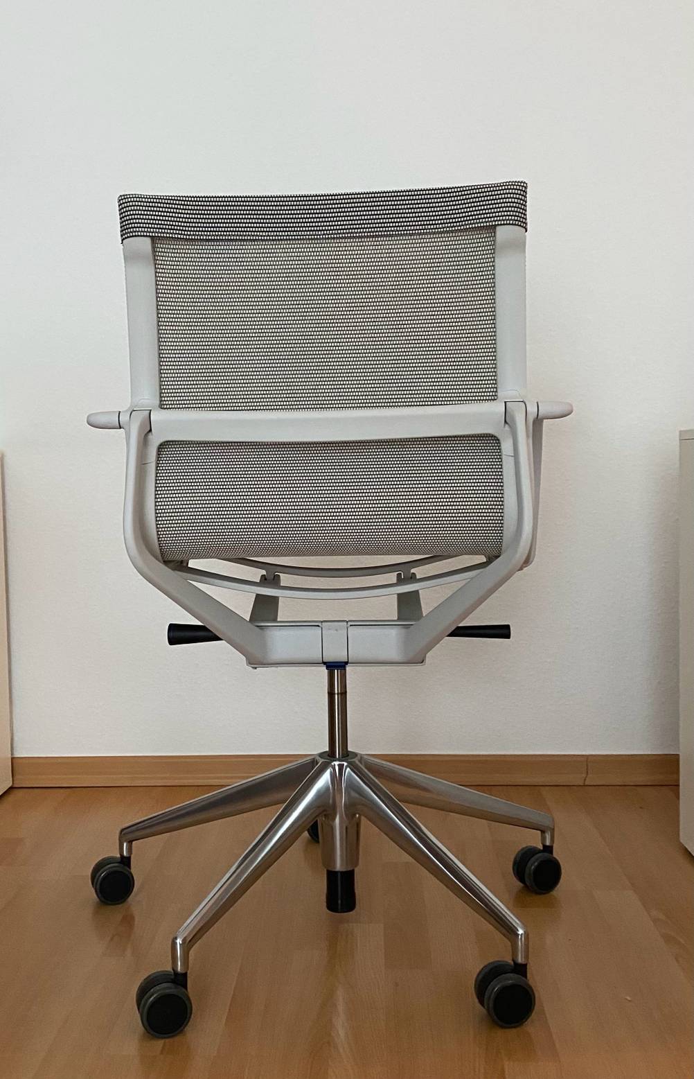 Ein Ergonomischer Bürostuhl im Test mit der Rückseite nach vorne vor einer hellen Wand.