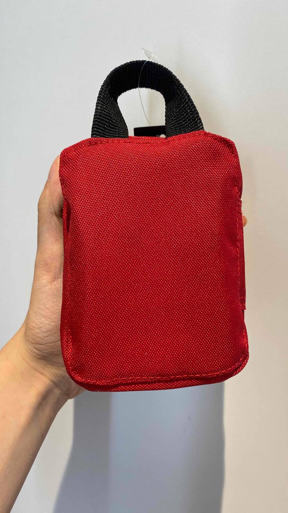 Rückseite des Erste-Hilfe-Set zum Wandern im Test von einer Hand gehalten.