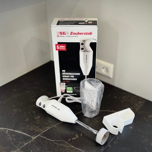 Stabmixer im Test: Der ESGE-Zauberstab steht zusammen mit dem Zubehör und der Verpackung auf einer Arbeitsfläche..