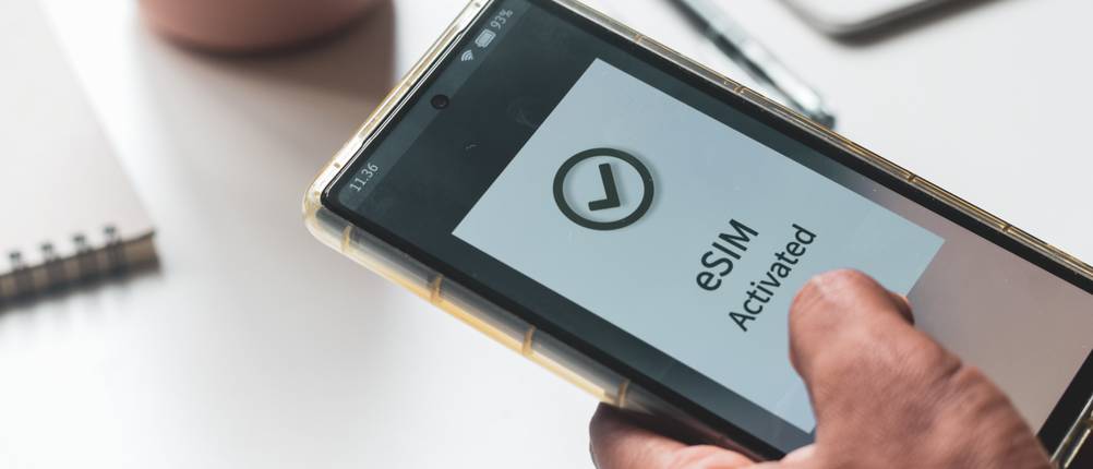 Eine Person hält ein Smartphone in der Hand, bei welchem gerade eine eSIM aktiviert wurde.