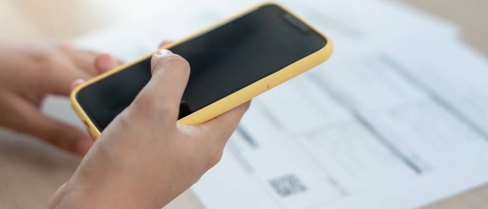 Eine Person scannt mit einem Smartphone einen QR-Code.