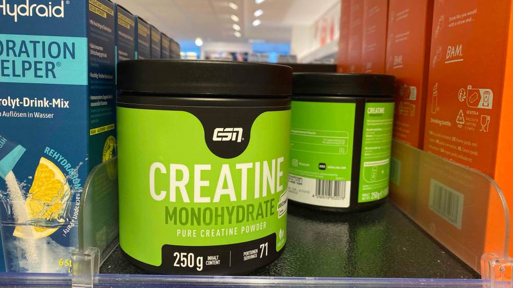 Im Test: Mehrere Dosen des Creatins stehen zwischen anderen Produkten in einem Verkaufsregal.