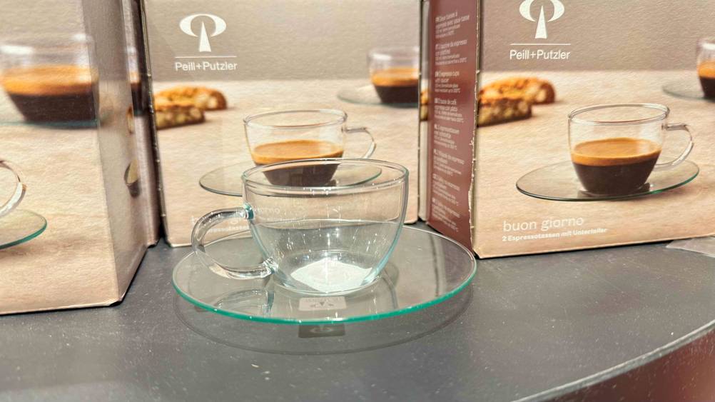 Espresso-Tassen im Test: Eine Tasse vor mehreren Originalverpackungen.