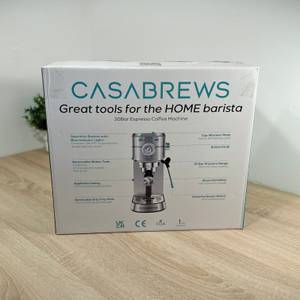 Die Verpackung der Casabrews-Espressomaschine steht auf einem Tisch.