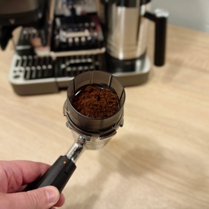Der Siebträger der Ninja-Espressomaschine ist mit der Dosierhilfe versehen und ist voller Kaffeepulver.