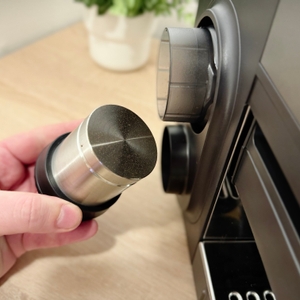 Der Tamper der Ninja-Espressomaschine wird aus seiner seitlichen Halterung gezogen.