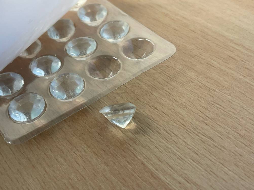 Der getestete essbare Glitzer neben der transparenten Verpackung auf einer Holzfläche.