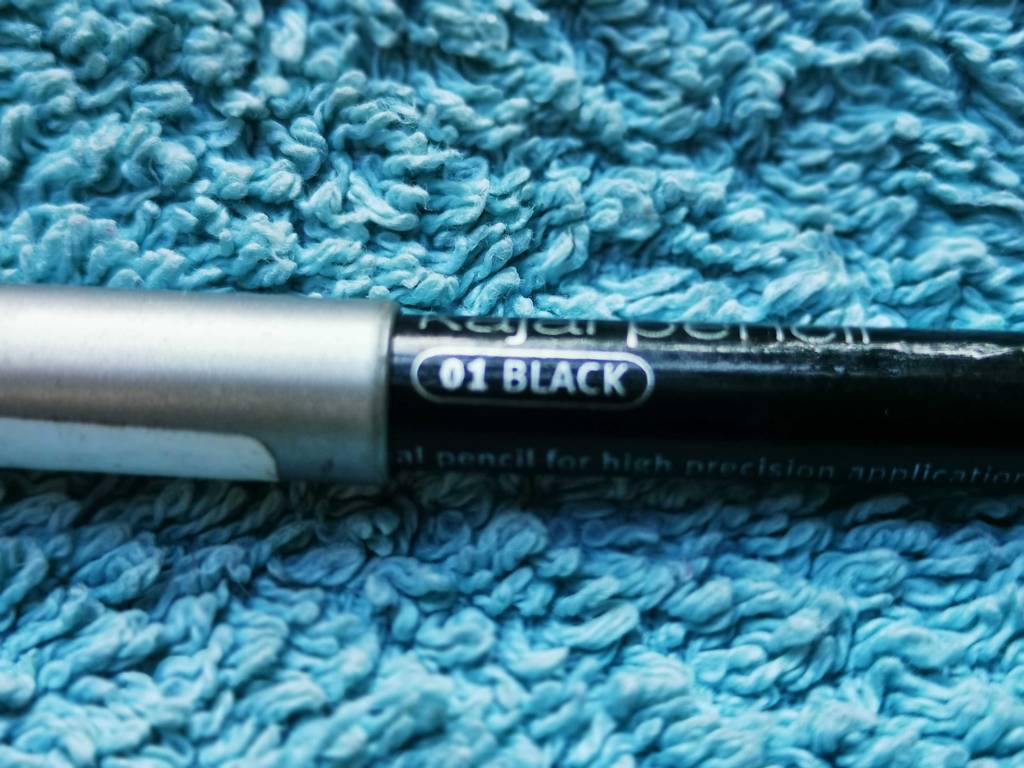 Der getestete Kajalstift in Schwarz liegt auf einem blauen Frotteestoff.