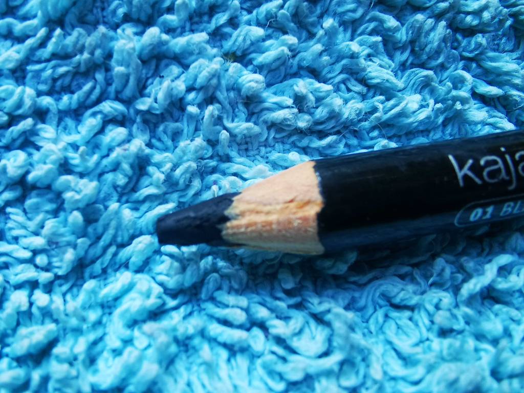 Detailansicht eines angespitzten Kajalstifts im Test, der auf einem blauen Frotteestoff liegt.