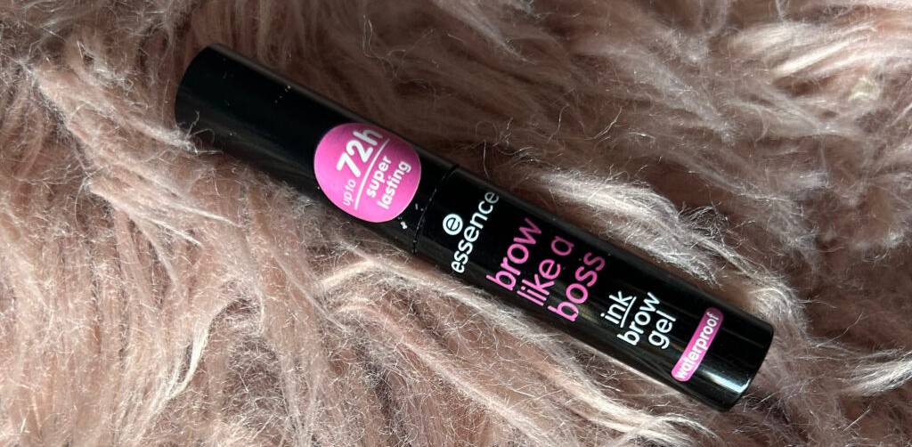Im Test: Augenbrauengel (bis zu 72 Stunden haltbar) in einer schwarzen Tube inklusive Pinsel liegt auf einem Kunstpelz.