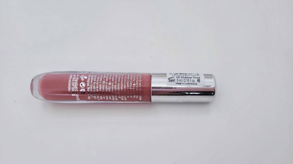 Lipgloss im Test: Ein verschlossenes Fläschchen liegt mit der Rückseite nach oben quer auf weißer Fläche.