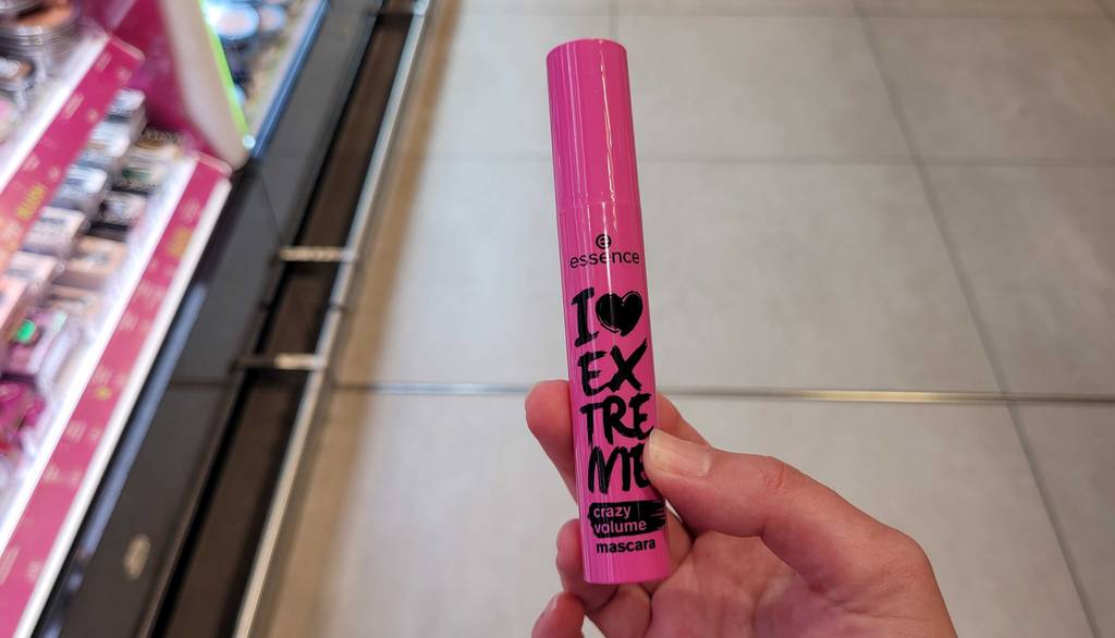 Der getestete Volumen-Mascara inklusive Bürste wird von einer Hand gehalten.