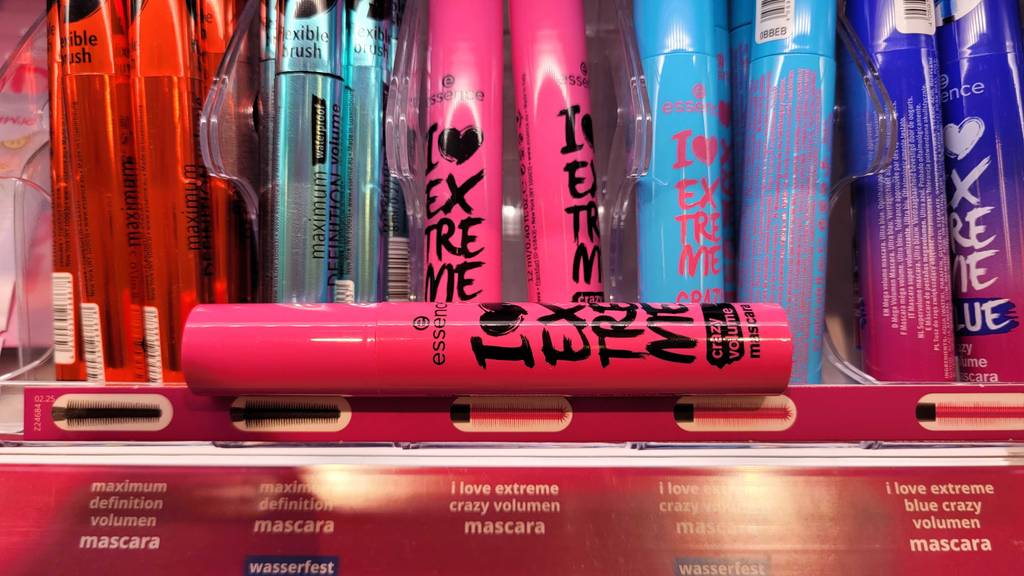 Im Test: Der Volumen-Mascara-Stift inklusive Bürste liegt auf einem Regal mit mehreren Volumen-Mascara.