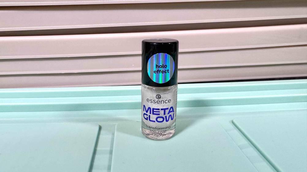 Auf einer blauen Fläche steht ein Fläschchen des getesteten Essence-Nagellack.