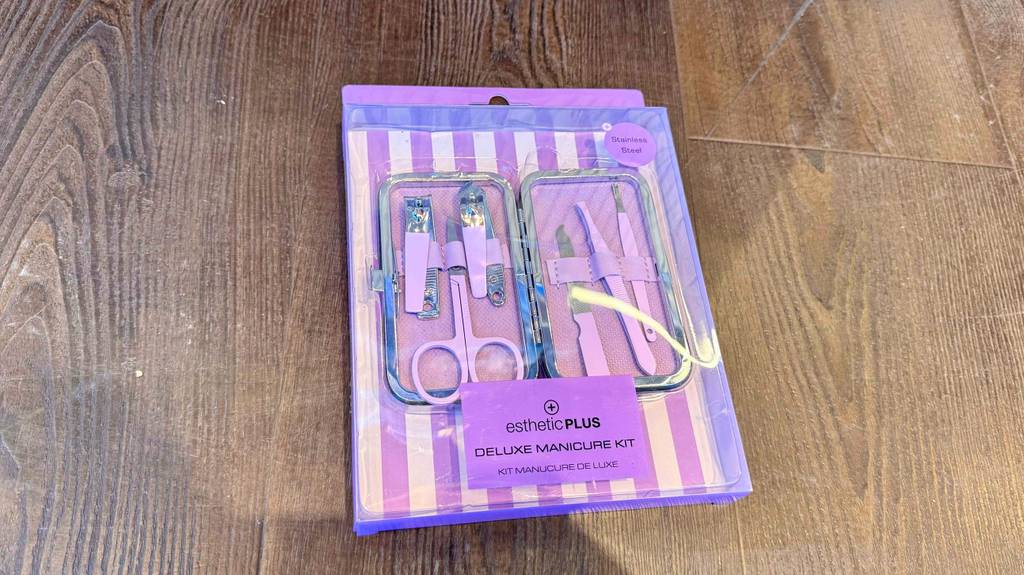 Ein Nagelpflegeset im Test liegt innerhalb seiner lilafarbenen Verpackung auf dem Boden.