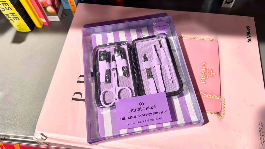 Im Test: Ein Nagelpflegeset in der lilafarbenen Verpackung liegt auf einem rosafarbenen Karton.
