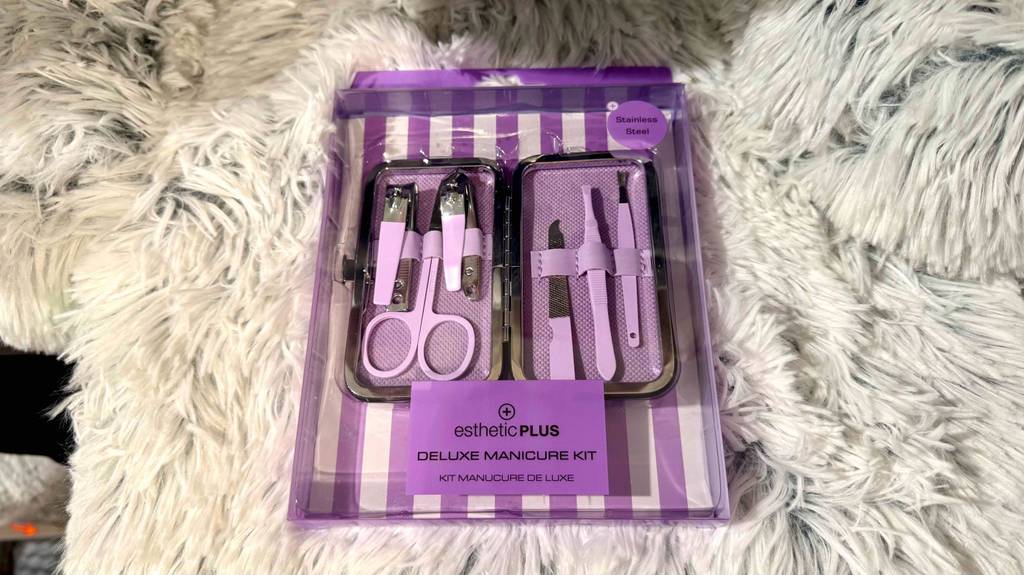 Ein getestetes Nagelpflegeset in einer lilafarbenen Verpackung liegt auf einem weißen Kunstfell.