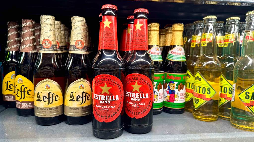 Spanisches Bier im Test: Eine braune Flasche mit rotem Etikett steht neben weiteren Bierflaschen auf einem Verkaufsregal.