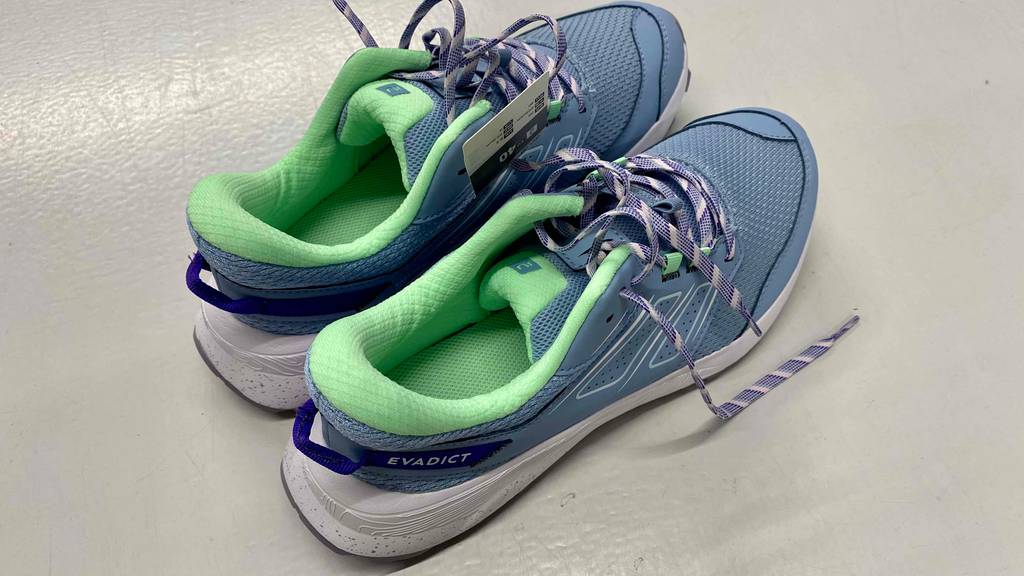 Im Test: Trailrunningschuhe für Damen in blau von Evadict stehen mit der Ferse nach vorn auf weißer Fläche.