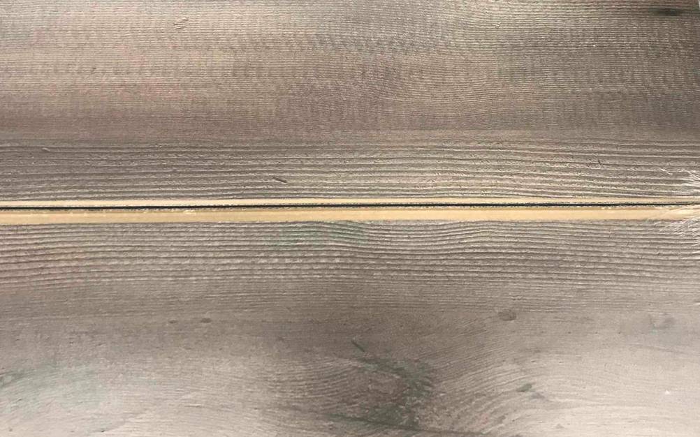 Nahaufnahme eines grauen, getesteten Holz-Laminats.