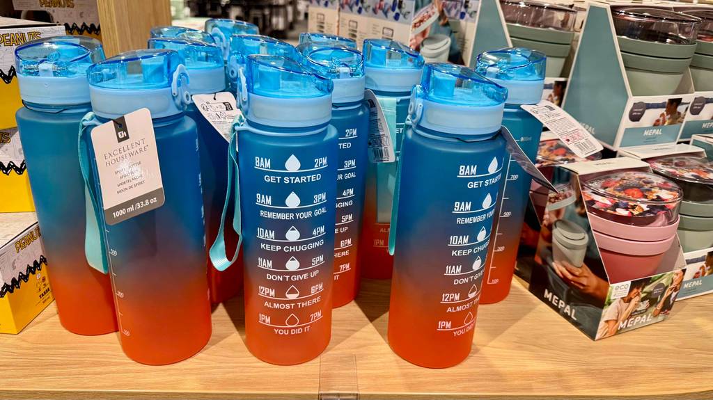 Blau-orange Fitness-Trinkflaschen im Test stehen nebeneinander auf einem Verkaufsregal.