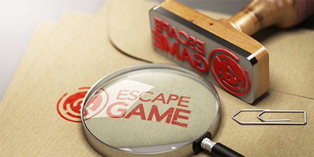 Exit-Adventskalender im Test: Ein Stempel mit der Aufschrift Escape Game und eine Lupe auf einem Umschlag