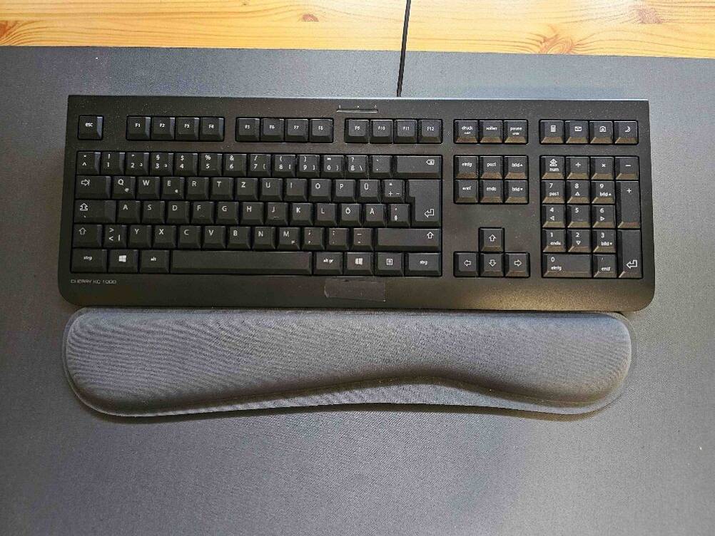 Eine Handballenauflage für die Tastatur liegt zum testen vor einer schwarzen PC-Tastatur.