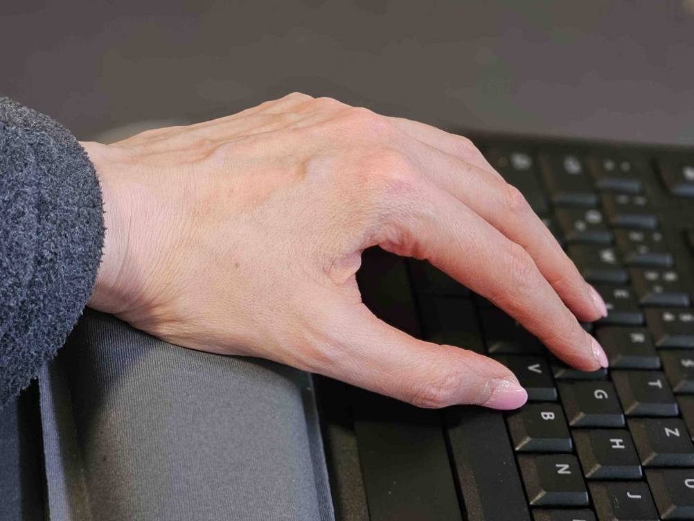 Seitenansicht einer Hand, die auf einer Handballenauflage für die Tastatur im Test liegt.