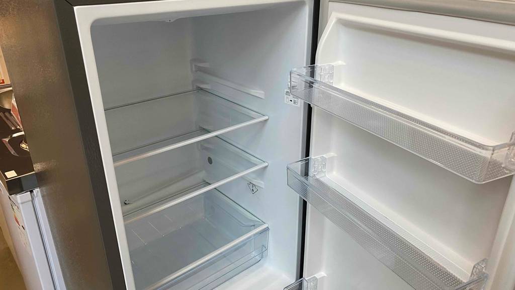 Kühl-Gefrierkombination getestet: oberer Innenraum zum Kühlen eines geöffneten Modells mit verstellbaren Glas-Ablageflächen und Schublade.