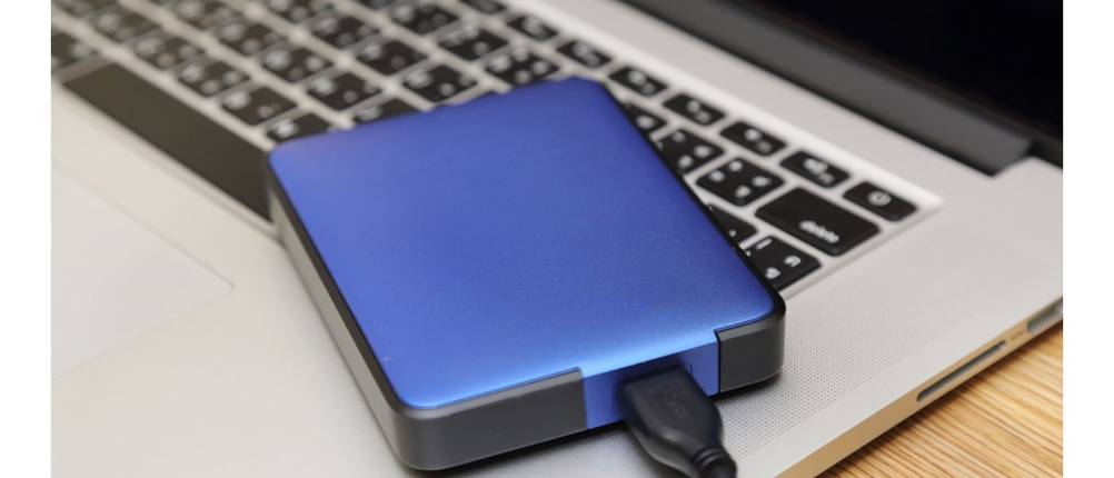 Festplattengehäuse-Test: Eine blaue externe Festplatte liegt auf einer Laptop-Tastatur