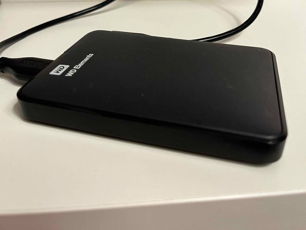 Eine getestete Externe Festplatte (1 TB) von schräg seitlich auf einer hellen Fläche.