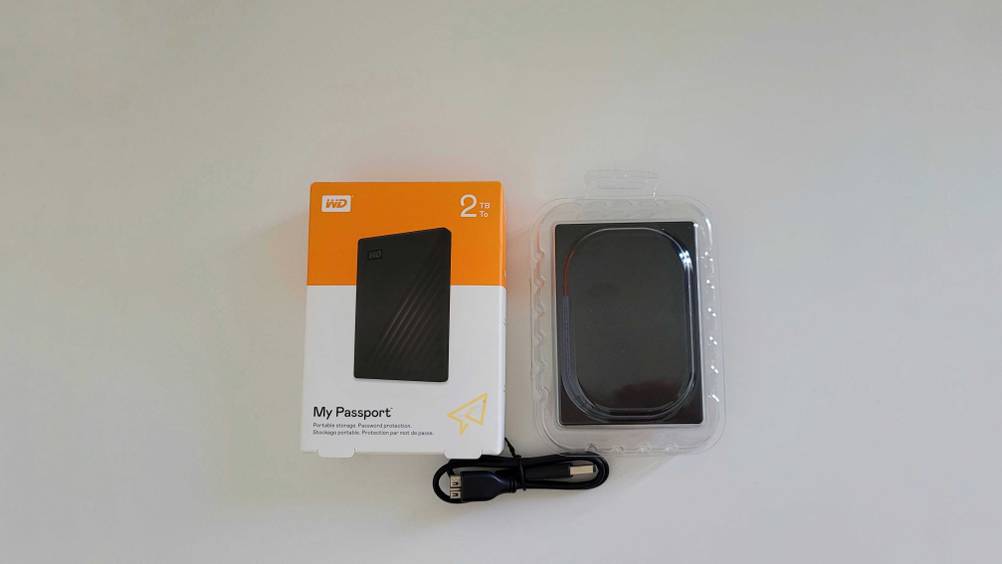 Im Test: Eine Originalverpackung, die transparent verpackte externe SSD-Festplatte (2TB) inklusive Kabel auf einer hellen Fläche.