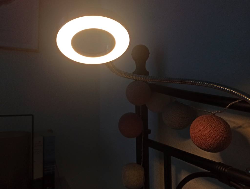 Hell leuchtende Leselampe an einem Bett.