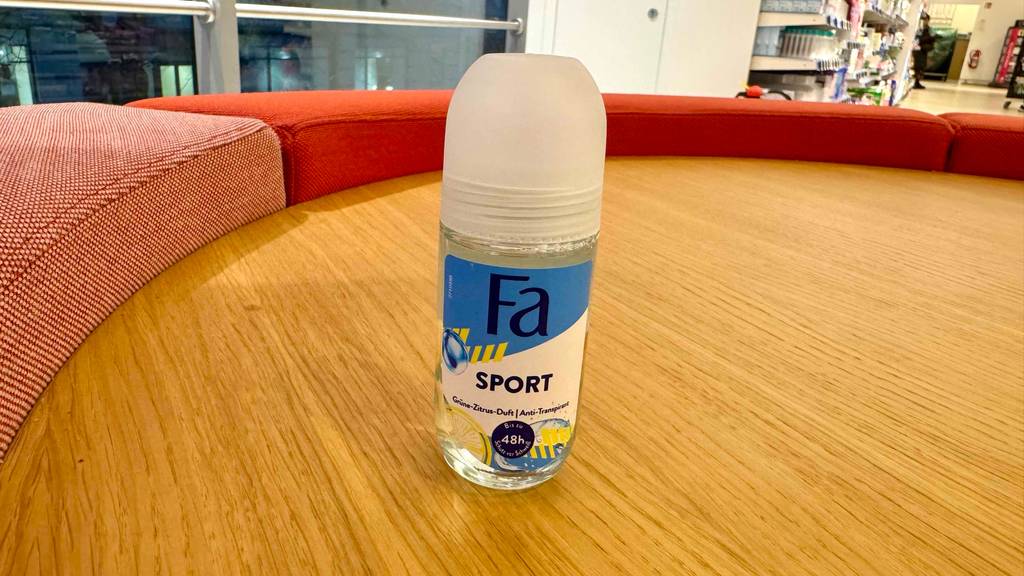 Ein Fläschchen Sport-Deo steht zum testen auf einer Holzfläche.