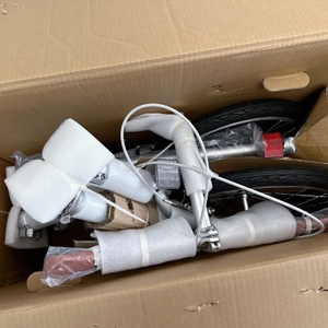 Zu sehen ist der vollständig verpackte Lieferumfang des FabricBike Folding Space Grey im Karton. Das Rad ist mit Schaumstoff und Kartonagen geschützt.