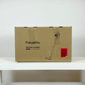 Die Vorderseite der Verpackung des Fabuletta FSV001 zeigt eine Zeichnung des Staubsaugers und den Modellnamen. Die Box steht auf einem Tisch.