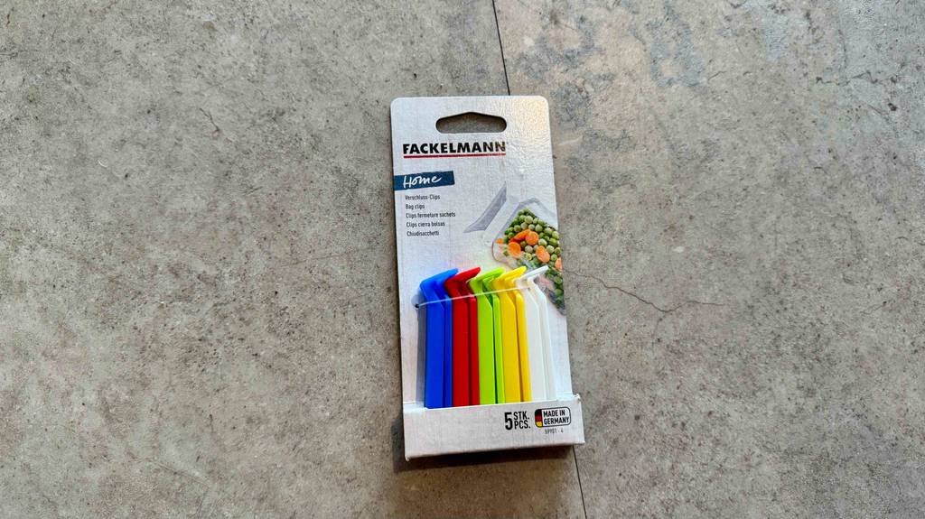 Fünf mehrfarbige getestete Verschlussclips in der Verpackung liegen auf dem Boden.