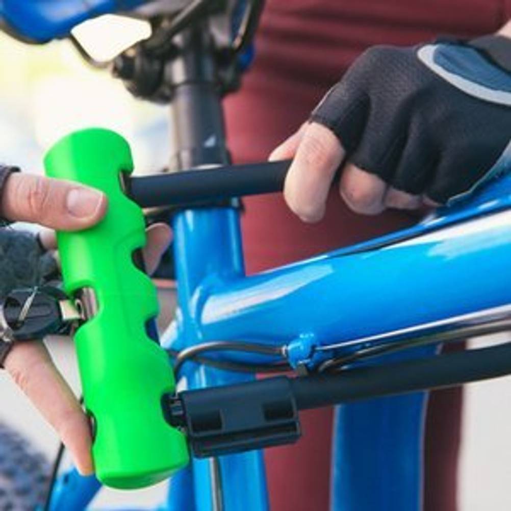 Fahrradfahrer, der ein Bügelschloss an einem Fahrrad befestigt