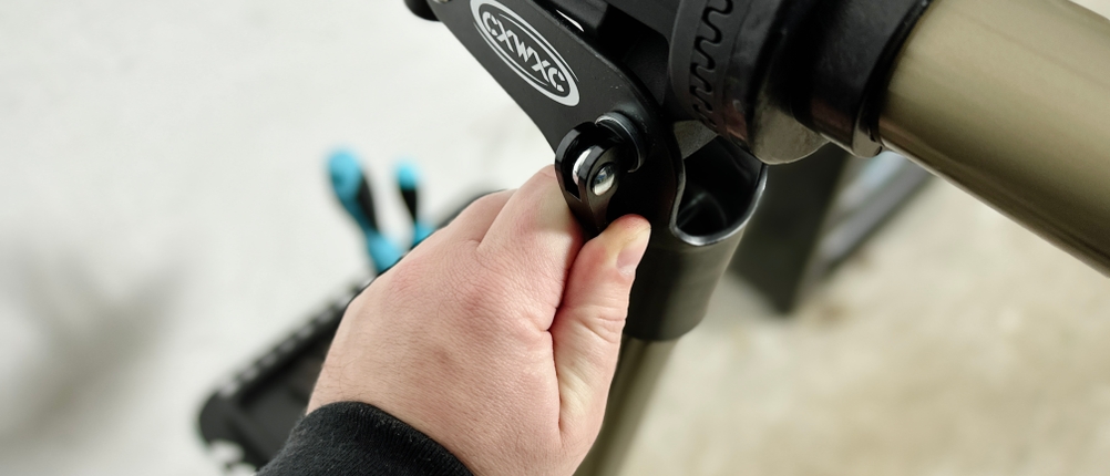 Eine Person stellt den Klemmmechanismus des Cxwxc-Fahrrad-Montageständers ein, um den Rahmen sicher zu fixieren.